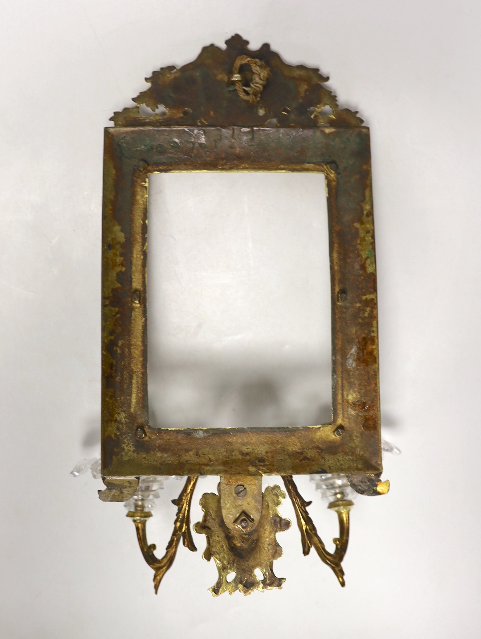 A decorative two branch ormolu wall mirror, lacking the mirror inset. 39cm tall overall, 16.5 x 11.5cm